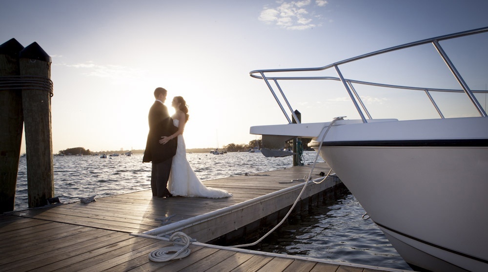 Bride and groom on a dock by the water
