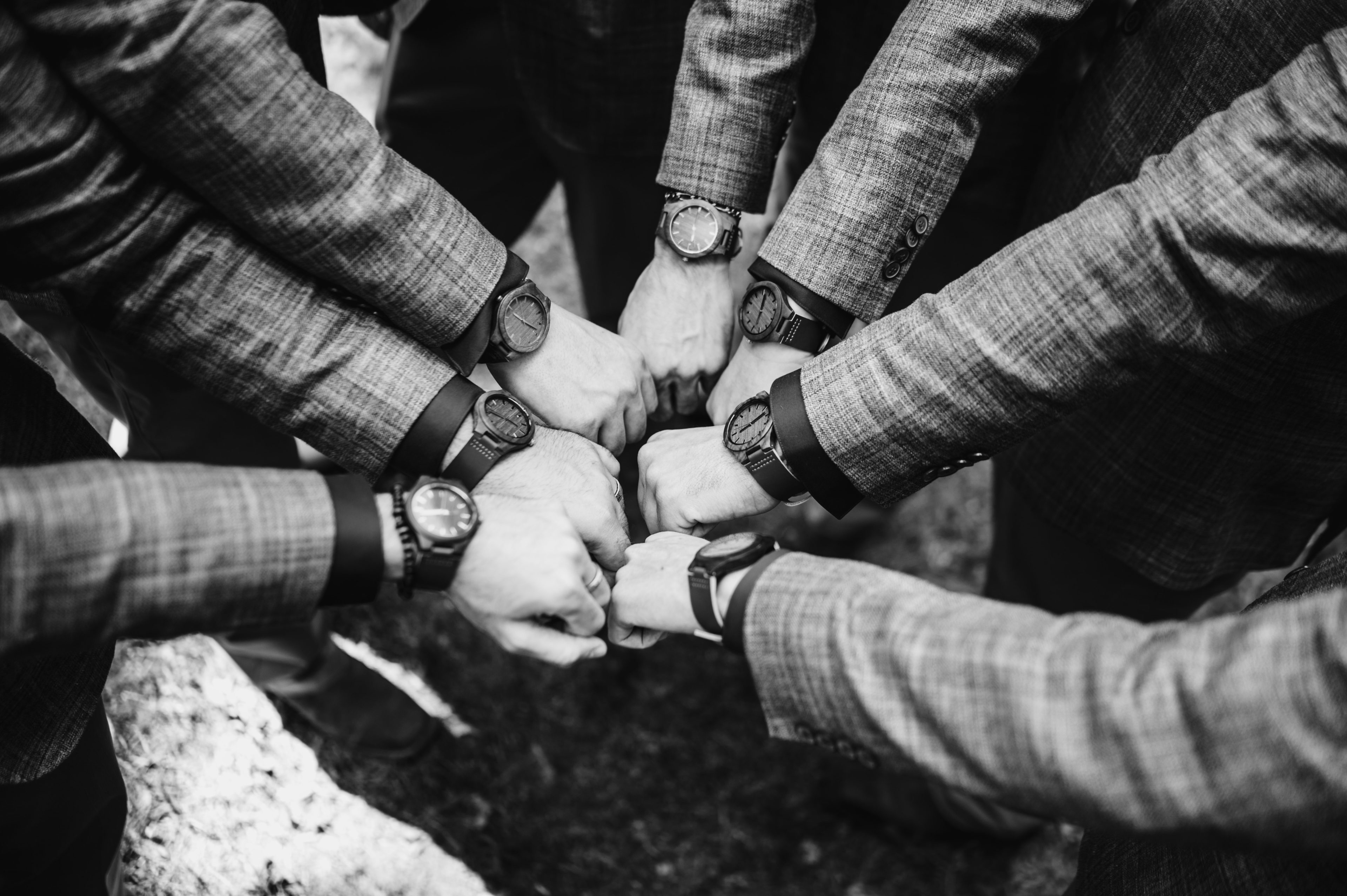 Groomsmen show off their matching watches in a circle