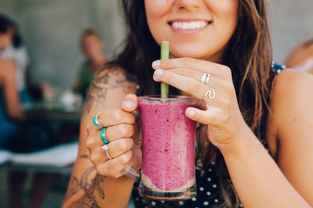 Happy woman drinking an Acai smoothie