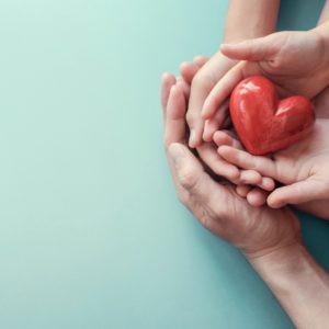Hands holding a heart shaped apple for World Health Day