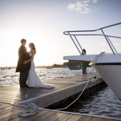 Bride and groom on a dock by the water