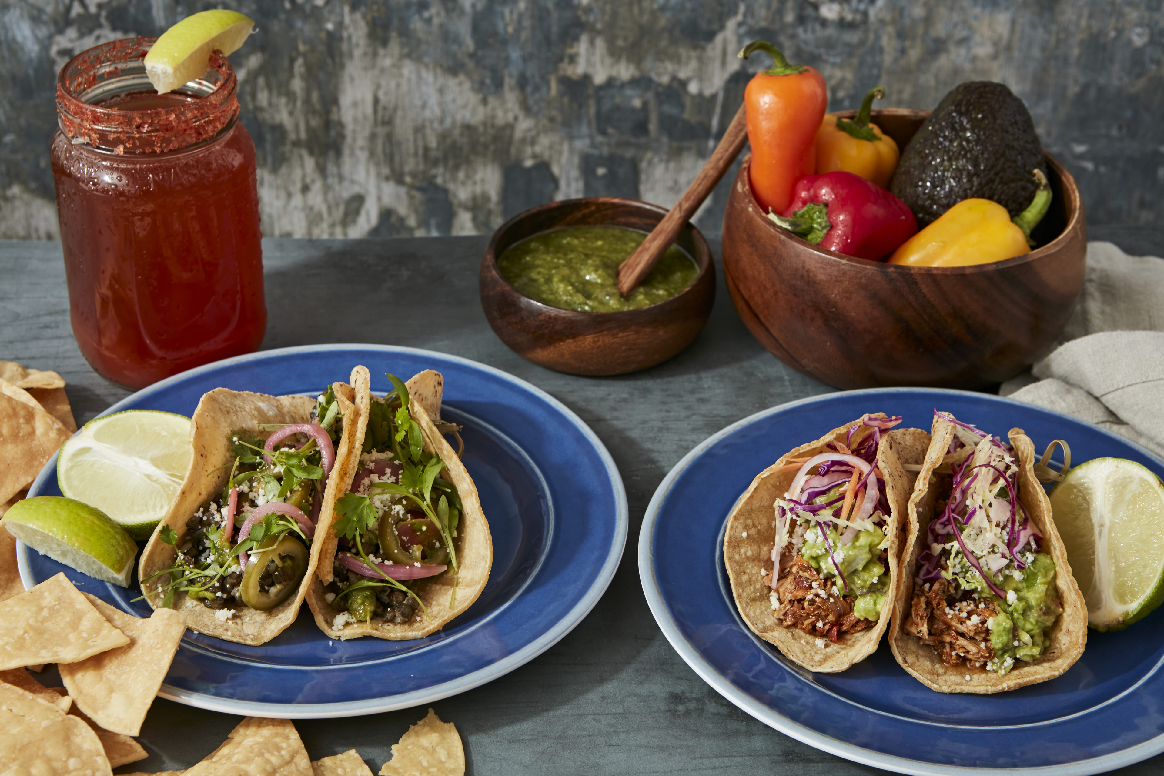 Plated tacos, salsa verde and chips, michelada
